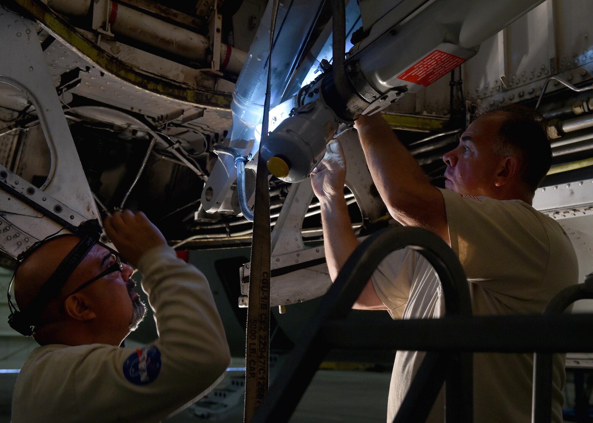 Gabe Quintana and James Isley, DynCorp B-377 Super Guppy maintainers, work on the Super Guppy’s landing gear, May 17, 2017, at Altus Air Force Base, Oklahoma. The Super Guppy and a crew of maintainers came to Altus AFB to do routine maintenance on its landing gear inside a hangar large enough to house it. (U.S. Air Force photo by Senior Airman Kirby Turbak/Released)