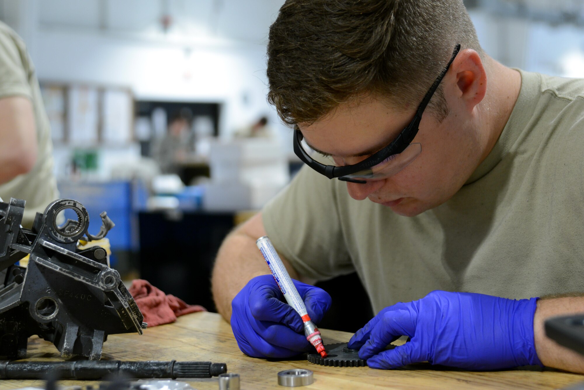 U.S. Air Force Airman 1st Class Michael Tilton, 20th Equipment Maintenance Squadron weapons technician, makes timing marks on a gear at Shaw Air Force Base, S.C., May 22, 2017. Tilton marked the gears to ensure they are properly aligned, or in time, with each other to correctly feed rounds of munitions to the transfer unit. (U.S. Air Force photo by Airman 1st Class Kathryn R.C. Reaves)