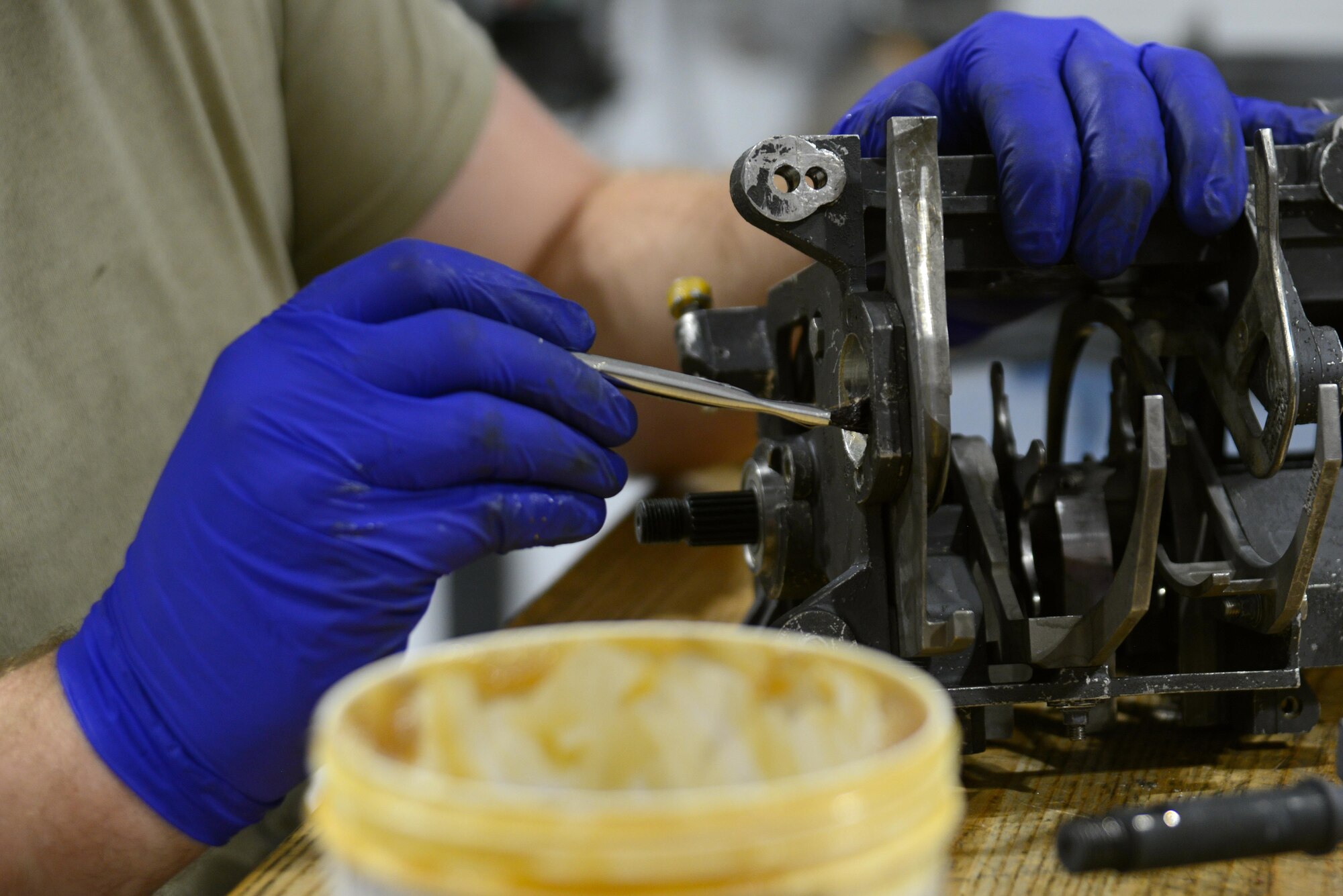 U.S. Air Force Airman 1st Class Michael Tilton, 20th Equipment Maintenance Squadron weapons technician, applies aircraft and instrument grease to an M61A1 Vulcan 20 mm rotary cannon exit unit at Shaw Air Force Base, S.C., May 22, 2017. The grease was applied to areas of friction on the unit to help the parts move freely. (U.S. Air Force photo by Airman 1st Class Kathryn R.C. Reaves)