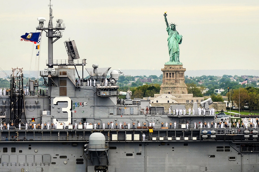 Sailors and Marines man the rails of the amphibious assault ship USS Kearsarge as it passes by the Statue of Liberty during the 29th annual Fleet Week New York's Parade of Ships in New York City, May 24, 2017. Navy photo by Chief Petty Officer Travis Simmons