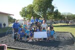 Susan Ralston, (center) Healthy Weight Commitment Foundation, senior advisor, presents a check to students at Randolph Elementary School, May 25, at Joint Base San Antonio-Randolph, also in the photo James Darren Robertson, (left) and David Robertson from PlayWell, parks and playground equipment.  The school won a playground set, $15,000 cash and $15,000 in sporting goods in a national contest.  (U. S. Air Force photo by Joel Martinez)           