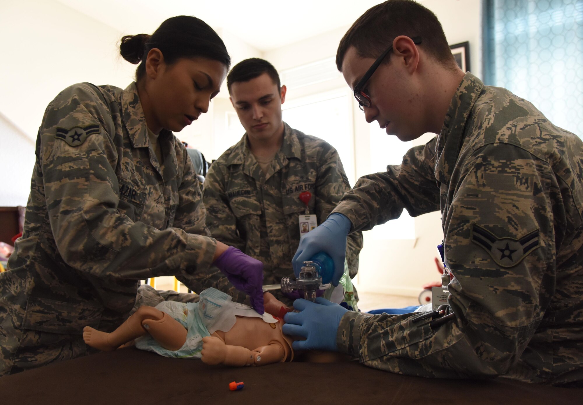Airman 1st Class Jacqueline Salazar, Senior Airman Brock Mauldin and Airman 1st Class Andrew Frost, 81st Medical Operations Squadron medical technicians, treat an infant “patient” found unresponsive in East Falcon subdivision May 24, 2017, in Biloxi, Miss., as part of a medical emergency scenario. Emergency room staff members coordinated with the simulation lab to use human patient simulators for running various advanced cardiac life support scenarios to improve Keesler’s new medical technicians’ skills and get them familiar with emergency equipment. (U.S. Air Force photo by Kemberly Groue)