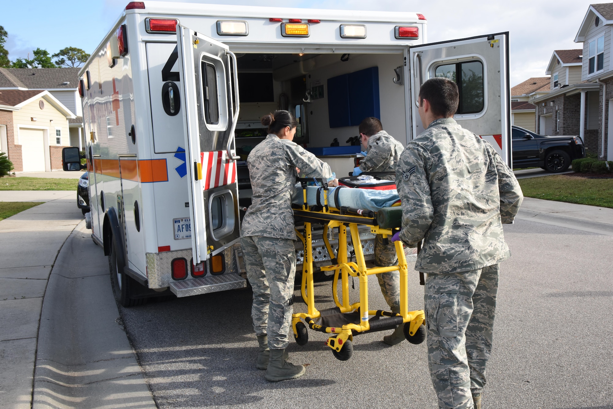 Airmen 1st Class Jacqueline Salazar and Andrew Frost and Senior Airman Brock Mauldin, 81st Medical Operations Squadron medical technicians, load an infant “patient” into an ambulance during a medical emergency scenario in East Falcon May 24, 2017, in Biloxi, Miss. Emergency room staff members coordinated with the simulation lab to use human patient simulators for running various advanced cardiac life support scenarios to improve Keesler’s new medical technicians’ skills and get them familiar with emergency equipment. (U.S. Air Force photo by Kemberly Groue)