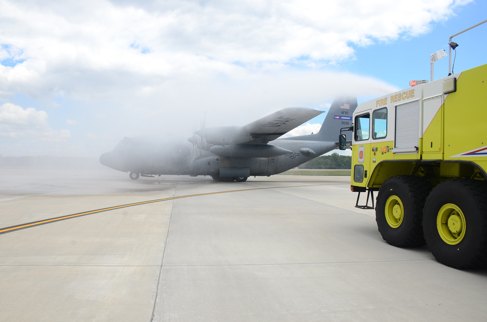 The Dobbins Fire Department hoses down a C-130 Hercules aircraft as Master Sgt. Steve Belcher, 700th Airlift Squadron loadmaster, performs his final C-130 flight at Dobbins Air Reserve Base May 25, 2017. Dating back to World War II, aircrew members have celebrated their last flights in similar fashion. Over the years, it has become an Air Force tradition for flyers. (U.S. Air Force photo/Don Peek)