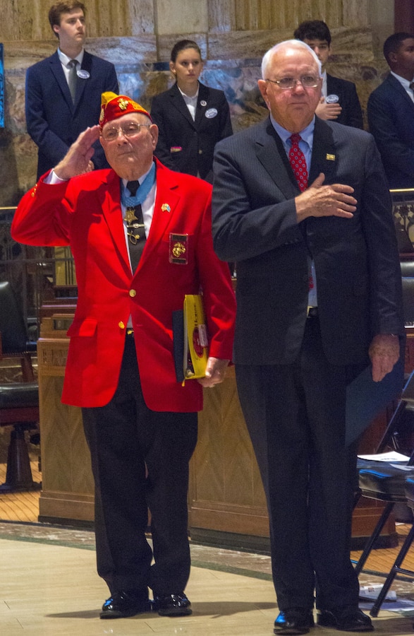 Retired Chief Warrant Officer 4 Hershel “Woody” Williams (left), a Medal of Honor recipient, and Dr. Nick Muller (right), president and chief executive officer of the WWII Museum, pay their respects during the Pledge of Allegiance at the Louisiana House of Representatives, in Baton Rouge, La., May 25, 2017. Muller and Williams were guests speakers for the Memorial Day Commemoration. The commemoration honors those who currently serve and have served in the military. (U.S. Marine Corps photo by Pfc. Melany Vasquez / Released) 