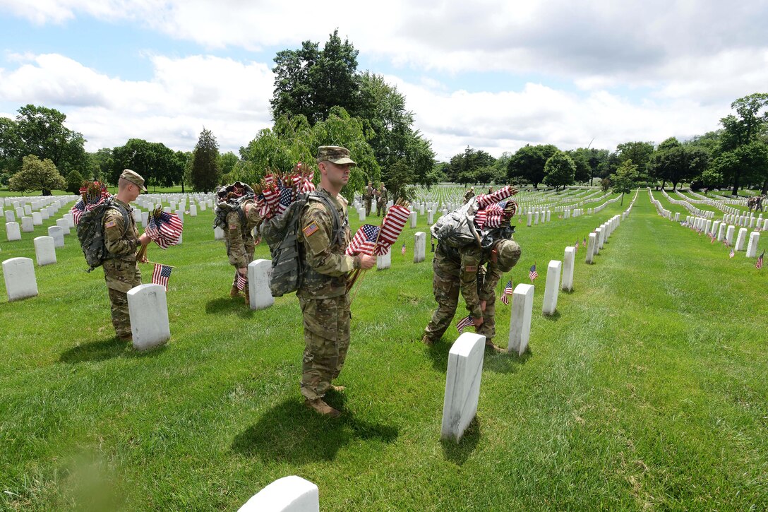 Soldiers place American flags in front of headstones during "Flags In" at Arlington National Cemetery in Arlington, Va., May 25, 2017. The soldiers, assigned to the 3rd U.S. Infantry Regiment known as "The Old Guard," placed more than 284,540 grave markers to honor every individual buried at Arlington National Cemetery. DoD photo by Sebastian J. Sciotti Jr.  