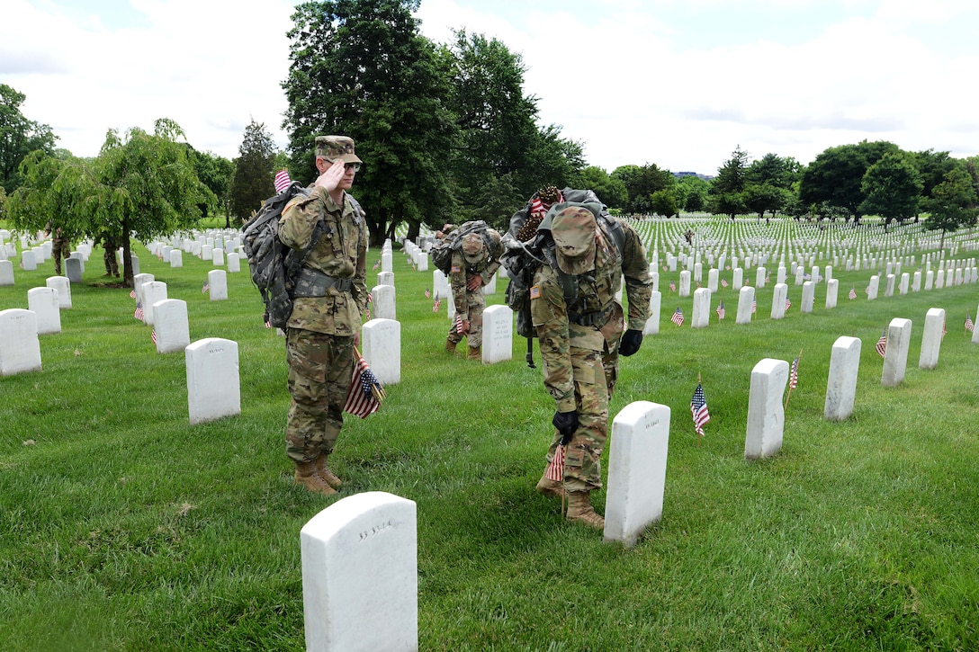 Army Pvt. Gabriel Thyfault, left, renders honors
