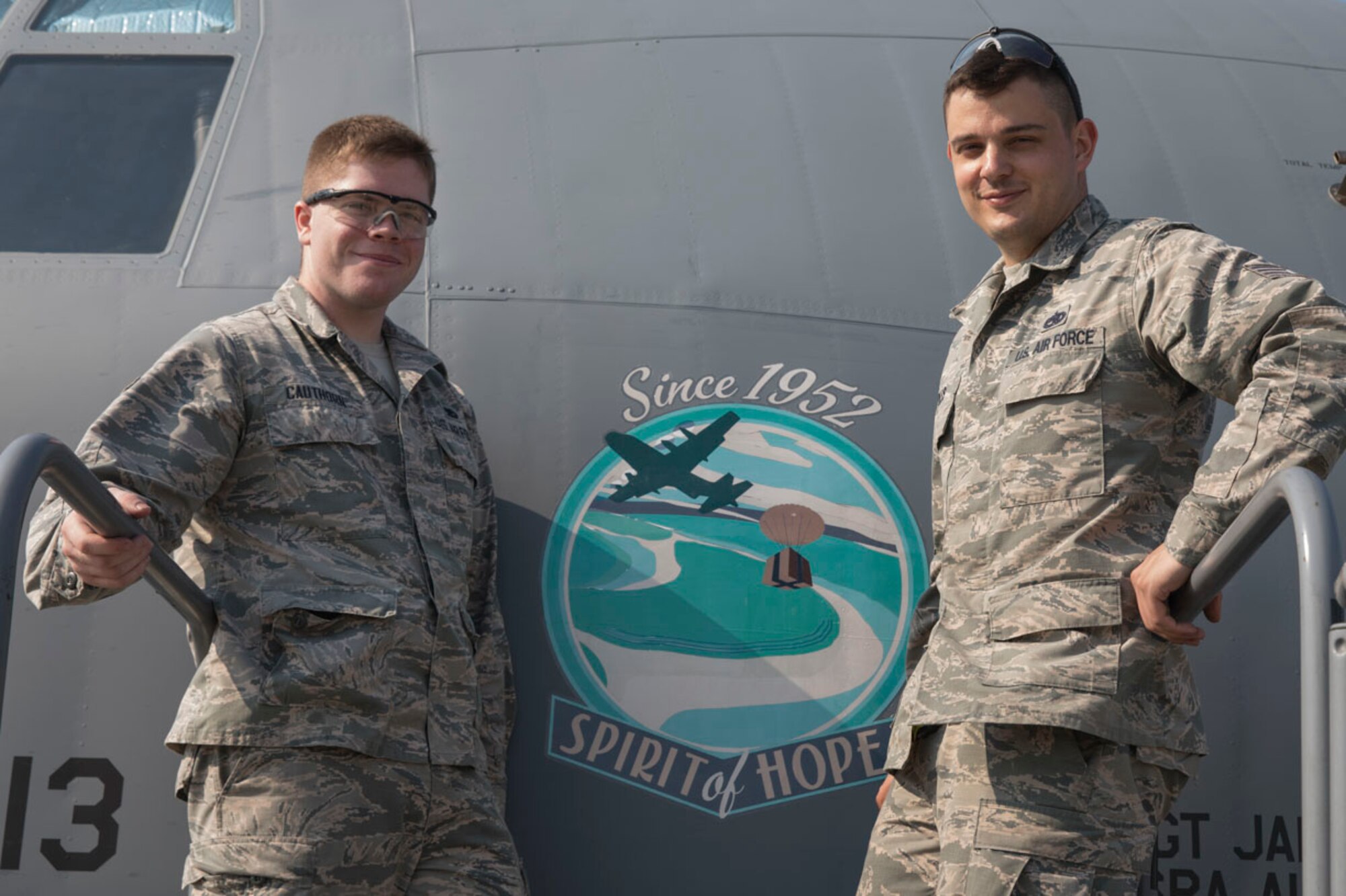 Airman 1st Class Caleb Cauthorn and Staff Sgt. Jared Boles, both with the 374th Maintenance Squadron aircraft structural maintenance, pose for a photo after placing the nose art onto a C-130J Super Hercules at Yokota Air Base, Japan, May 19, 2017. The nose art design, "Spirit of Hope," which was designed and donated by graphic artist Samantha Beaty, celebrates the United States Air Force's dedication to providing humanitarian assistance and disaster relief to nations throughout the Indo-Asia-Pacific region. The artwork itself is a rendering of an Air Force C-130 airdropping humanitarian aid during Operation Christmas Drop. For 65 years running, Yokota Air Base aircraft and personnel have supported this event. In 2016 alone, four Yokota Air Base C-130s, along with the Royal Australian Air Force and Japan Air Self-Defense Force, airdropped 25 tons of aid to 25,000 people spread across 56 Micronesian Islands. (U.S. Air Force photo by Yasuo Osakabe)