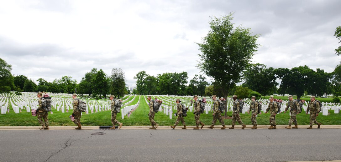 Soldiers carrying American flags in backpacks, walk to their designated areas before participating in "Flags In" at Arlington National Cemetery in Arlington, Va., May 25, 2017. DoD photo by Sebastian J. Sciotti Jr.