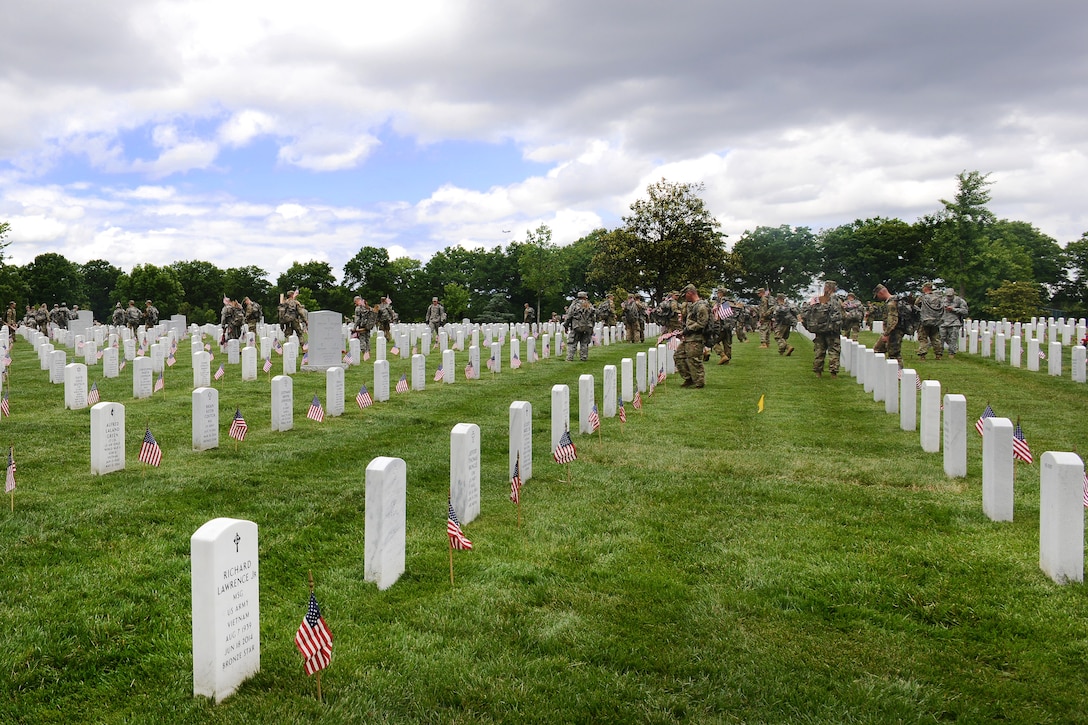 Soldiers assigned to the 3rd U.S. Infantry Regiment, known as "The Old Guard," place American flags in front of headstones during "Flags In" at Arlington National Cemetery in Arlington, Va., May 25, 2017. DoD photo by Sebastian J. Sciotti Jr.