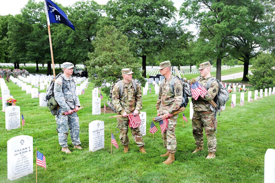 Army Col. Jason Garkey, center right, commander, 3rd U.S. Infantry Regiment, known as "The Old Guard,” receives an update from Army Capt. Marc D’Eredita, center left, before his soldiers participate placing American flags in front of headstones during "Flags In" at Arlington National Cemetery in Arlington, Va., May 25, 2017. D’Eredita is the commander, 3rd U.S. Infantry Regiment, "The Old Guard,” Company H. DoD photo by Sebastian J. Sciotti Jr.