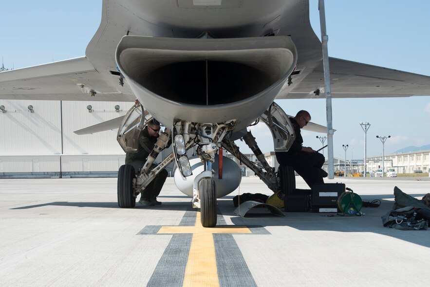 U.S. Air Force Maj. Richard Smeeding, left, the Pacific Air Forces F-16 Demonstration Team pilot, executes his pre-flight inspection while Tech. Sgt. Tristan Berger, right, a PACAF F-16 Demonstration Team aerospace propulsion craftsman, reviews a technical order at Marine Corps Air Station Iwakuni, Japan, May 22, 2017. The team travels throughout the PACAF area of responsibility to showcase the power and maneuverability of the F-16 Fighting Falcon. (U.S. Air Force photo by Staff Sgt. Melanie Hutto)