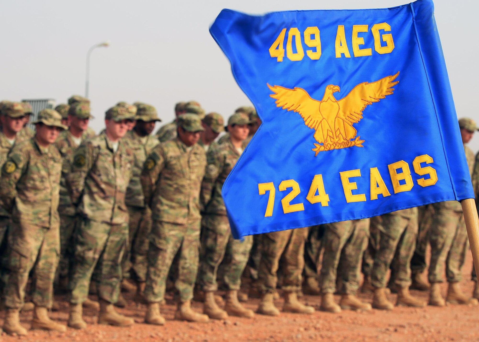 The 724th Expeditionary Air Base Squadron’s guidon catches the wind during a change of command ceremony at Nigerien Air Base 201, Niger, May 15, 2017. During change of command ceremonies, guidons are passed to symbolize the handing over of the unit from one commander to the next. (U.S. Air Force photo by Senior Airman Jimmie D. Pike)