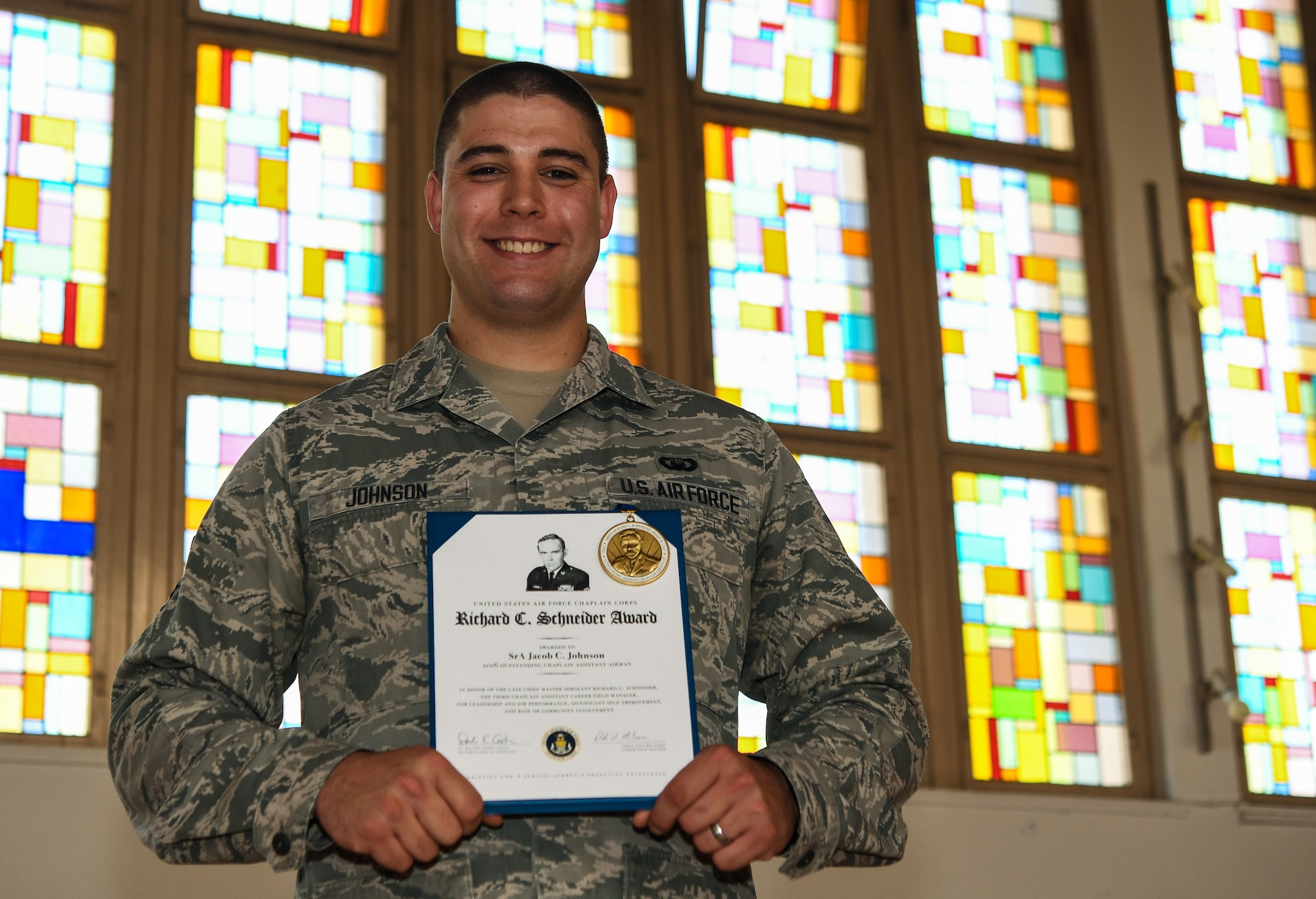 U.S. Air Force Staff Sgt. Jacob Johnson, 86th Airlift Wing Chapel education and training noncommissioned officer in-charge displays his U.S. Air Force Chaplain Corps Richard C. Schneider Award for 2016 outstanding chaplain assistant airman for his duties on Ramstein Air Base, Germany, May 15, 2017. Johnson was recognized his exceptional duties at Edwards Air Force Base and Ramstein AB. (U.S. Air Force photo by Staff Sgt. Nesha Humes)