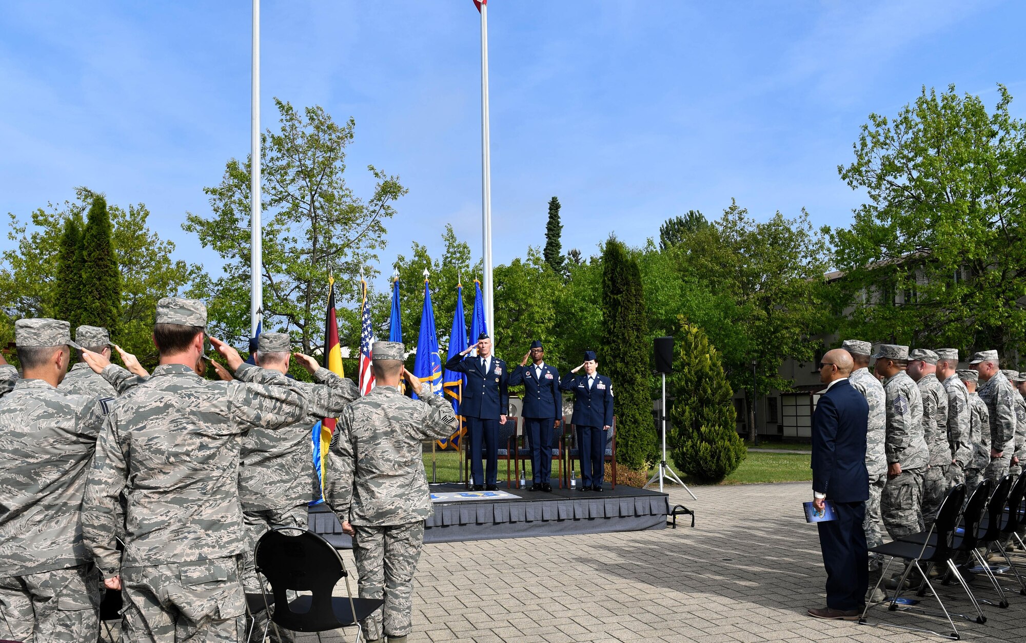 The official party and guests of the Kisling Noncommissioned Officer Academy Change of Responsibility ceremony salute during the playing of the U.S. and German national anthems on Kapaun Air Station, Germany, May 25, 2017. During the ceremony, U.S. Air Force Chief Master Sgt. Tamar Dennis, outgoing Kisling NCOA commandant, relinquished responsibility of the academy to U.S. Air Force Chief Master Sgt. Kathi Glascock, incoming  Kisling NCOA commandant. The Change of Responsibility ceremony is the enlisted version of an officer’s change of command, where one leader passes command to the next, and dates back to the time of knighthood. (U.S. Air Force photo by Senior Airman Tryphena Mayhugh)