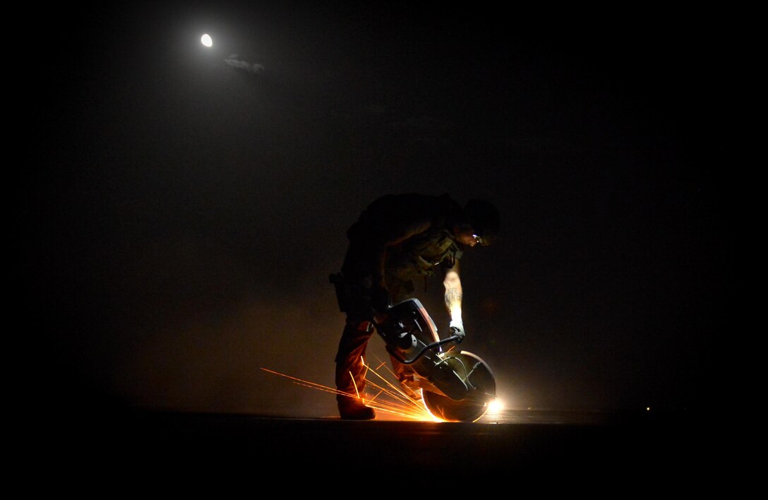 A member of the 1st Expeditionary Civil Engineer Group cuts out the damaged regions of the Qayyarah West Airfield flightline during a restoration project May 16, 2017. Qayyarah West is an airfield in northern Iraq’s Ninawa Province and serves as the logistical hub and strategic launching pad resupplying the frontlines in an attempt to recapture Mosul. (U.S. Air Force photo/Staff Sgt. Michael Battles)
