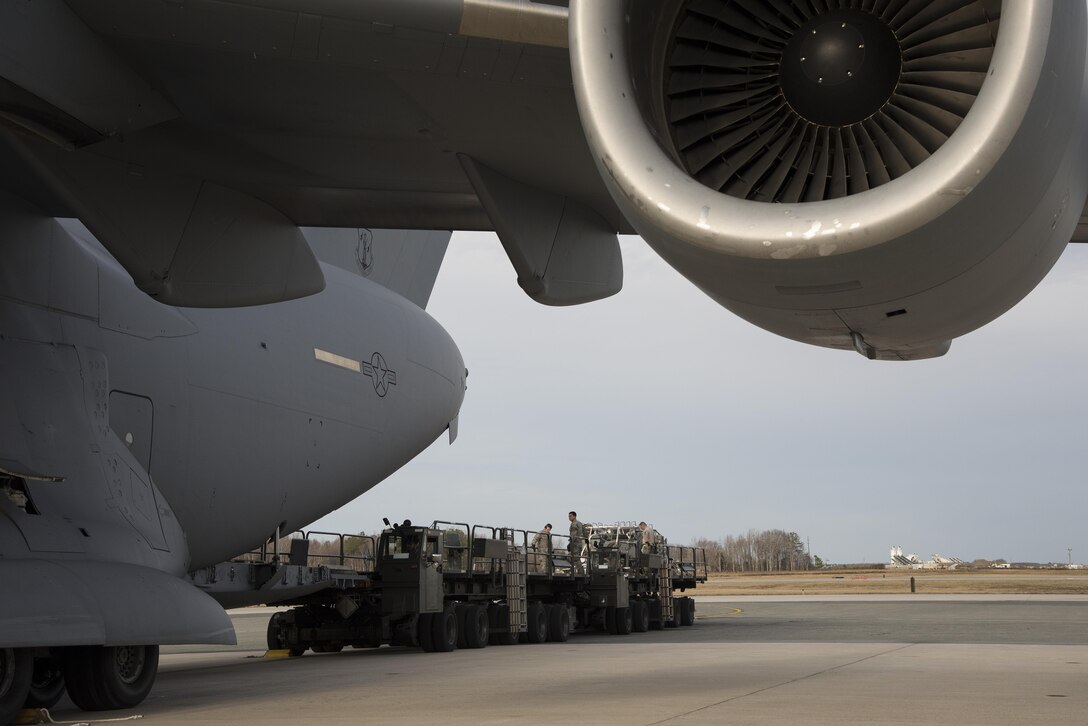Aerial port expediters assigned to the 436th Aerial Port Squadron offload a C-17 Globemaster III Jan. 12, 2017, at Dover Air Force Base, Del. The unit’s ability to load and offload aircraft without loadmasters present allows work to be spread out more evenly, especially when peak workloads are expected. (U.S. Air Force photo by Senior Airman Aaron J. Jenne)