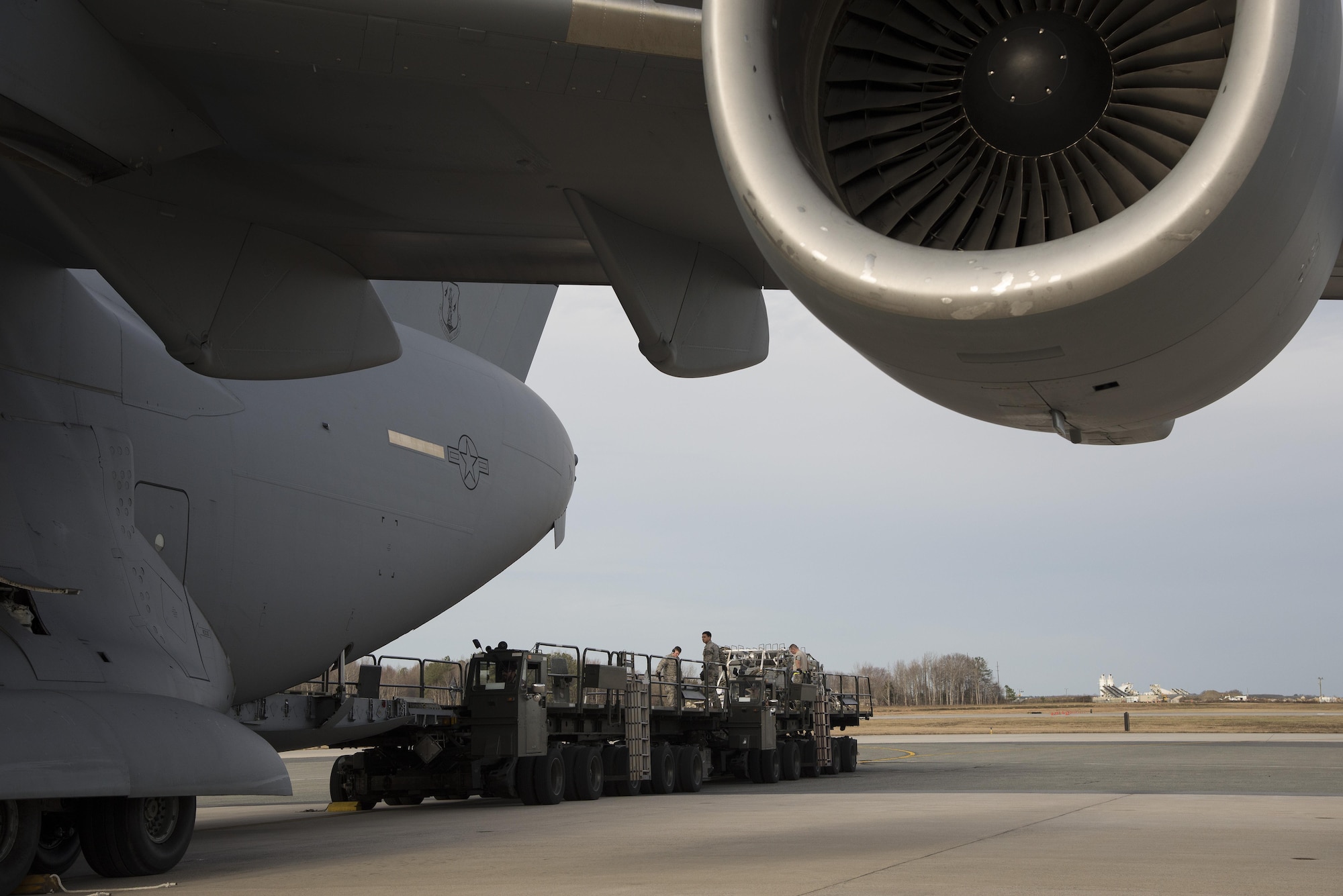 Aerial port expediters assigned to the 436th Aerial Port Squadron offload a C-17 Globemaster III Jan. 12, 2017, at Dover Air Force Base, Del. The unit’s ability to load and offload aircraft without loadmasters present allows work to be spread out more evenly, especially when peak workloads are expected. (U.S. Air Force photo by Senior Airman Aaron J. Jenne)