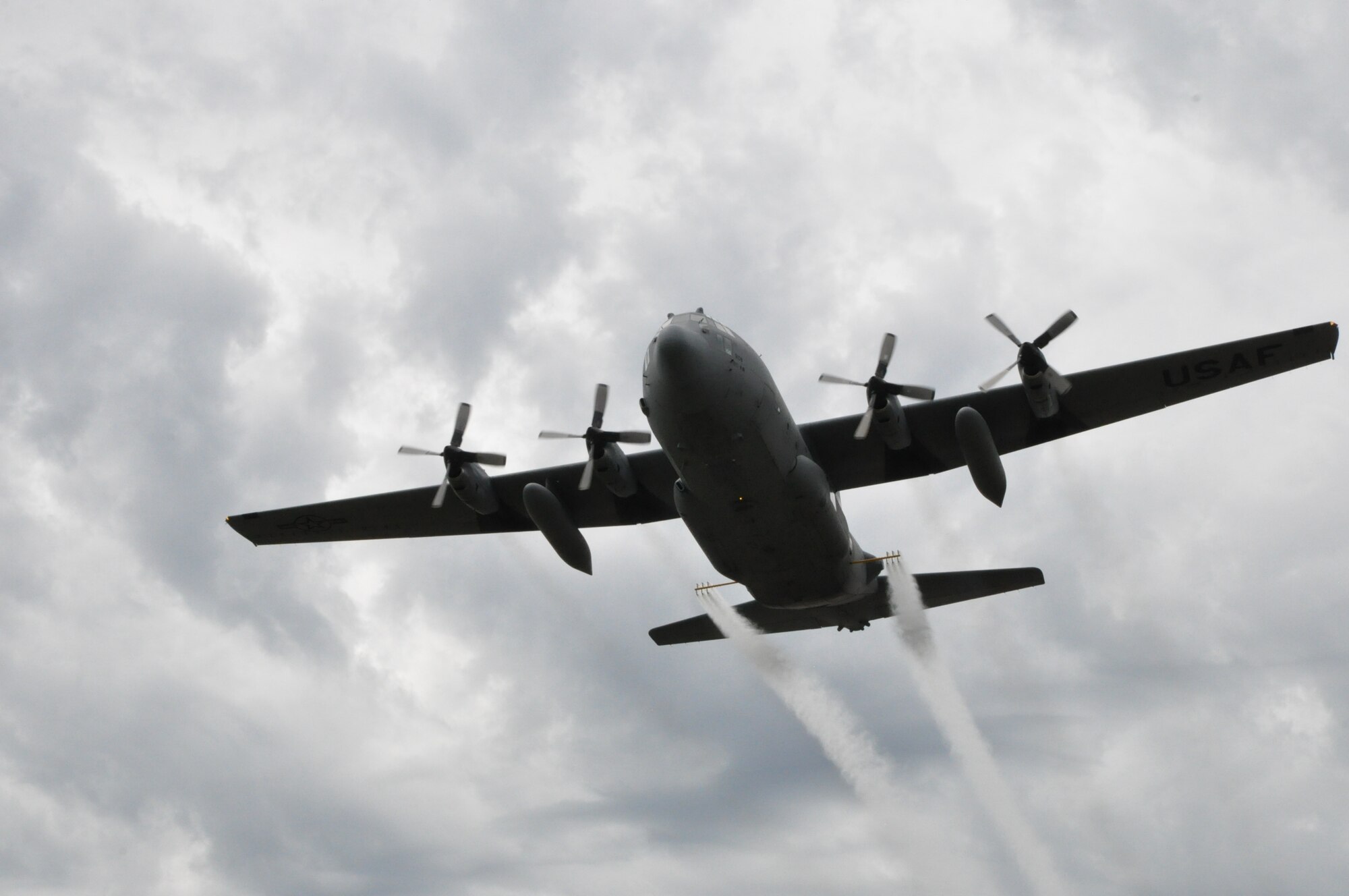 A Youngstown C-130H Hercules aircraft, modified for the Department of Defense's only aerial spray mission, demonstrates its capability by flying low and spraying water through a Modular Aerial Spray System used only for training during the annual aerial spray course here, May 10, 2017. This flight simulates a pesticide mission which can eliminate pest or disease-carrying insects to protect Service members. (U.S. Air Force photo/Master Sgt. Bob Barko Jr.)