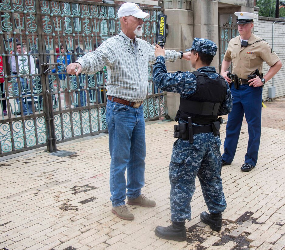 Marine Corps and Naval security support elements conduct security checks as guests arrive to the Naval Academy during the 2017 United States Naval Academy Commissioning Week, Annapolis, Md., May 25, 2017.  Guard Marines with Marine Barracks Washington were called upon to support as an additional security element for this year’s Commissioning Week. (Official Marine Corps photo by Cpl. Robert Knapp/Released)