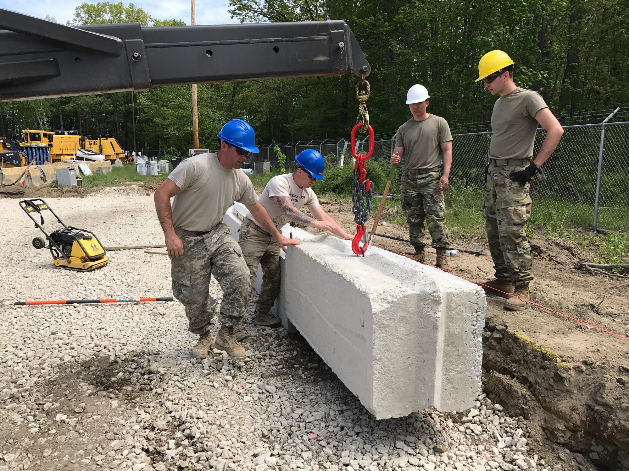 Airmen of the 157th Civil Engineer Squadron and Soldiers of Detachment 2, 160th Engineer Company place a block May 21, 2017, at  Pease Air National Guard Base, N.H. The joint team of New Hampshire National Guard members collaborated on four construction projects during a two-week training period. (U.S. Air National Guard Photo By Master Sgt. Thomas Johnson)