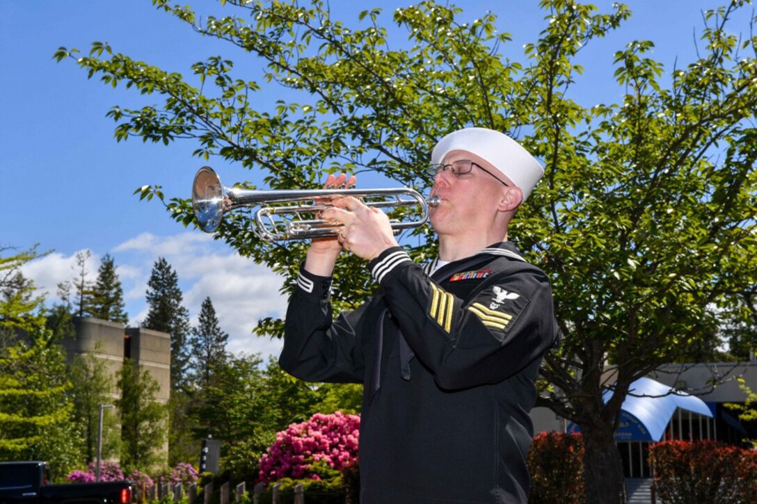 Navy Petty Officer 1st Class Christopher Hodges, assigned to Navy Band Northwest, plays taps during the annual Memorial Day "Tolling the Boats" observance at Deterrent Park on Naval Base Kitsap in Washington, May 25, 2017. Sixty-five U.S. submarines have been lost since 1915, including 52 lost during World War II. Navy photo by Petty Officer 3rd Class Charles D. Gaddis IV