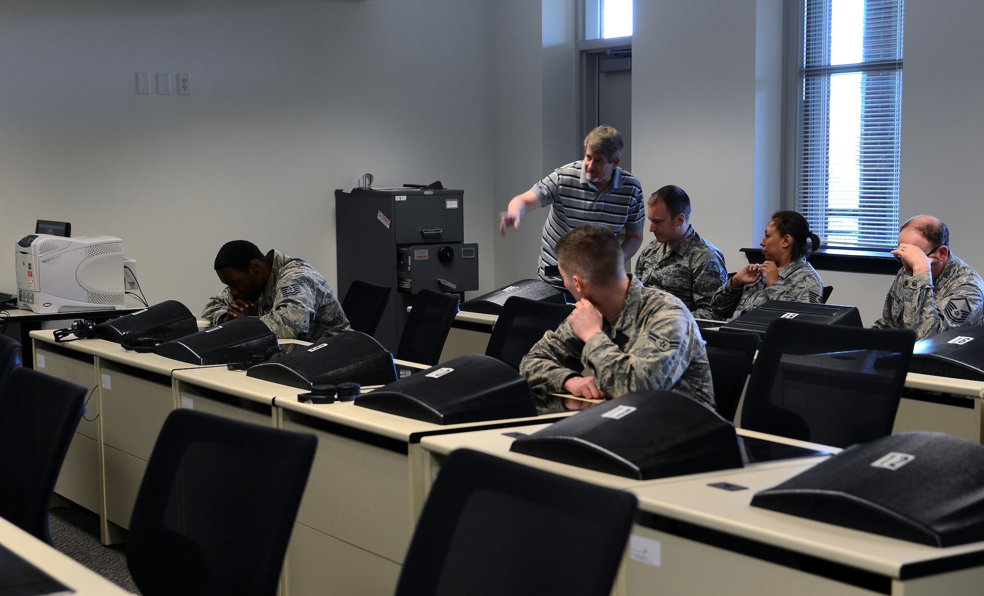 Patrick Geagon, force development McChord testing center test control officer, shows Airmen how to access test material May 25, 2017, at Joint Base Lewis-McChord, Wash. Annually, the testing center administers more than 5,000 tests and can issue up to 250 tests weekly. (U.S. Air Force photo/Senior Airman Jacob Jimenez)   