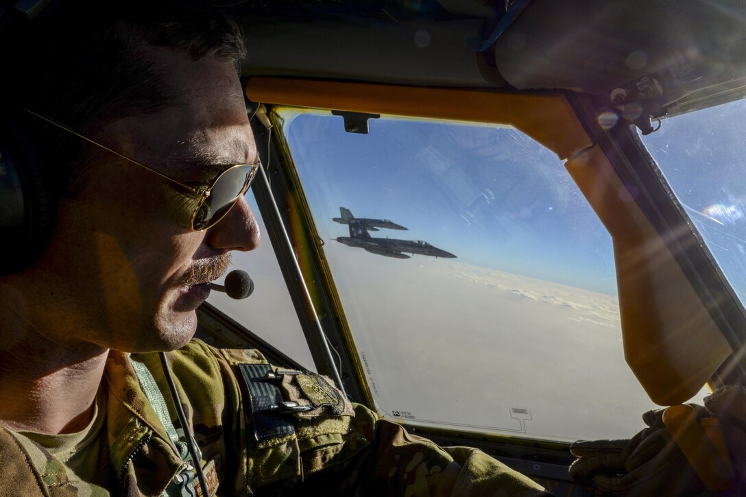 Air Force Capt. Timothy Black pilots a KC-135 Stratotanker on a combat refueling mission over Southwest Asia while two Navy F/A-18C Hornets fly alongside it, May 21, 2017. The Stratotanker is assigned to the 340th Expeditionary Air Refueling Squadron, which supports Operation Inherent Resolve. Air National Guard photo by Master Sgt. Andrew J. Moseley
