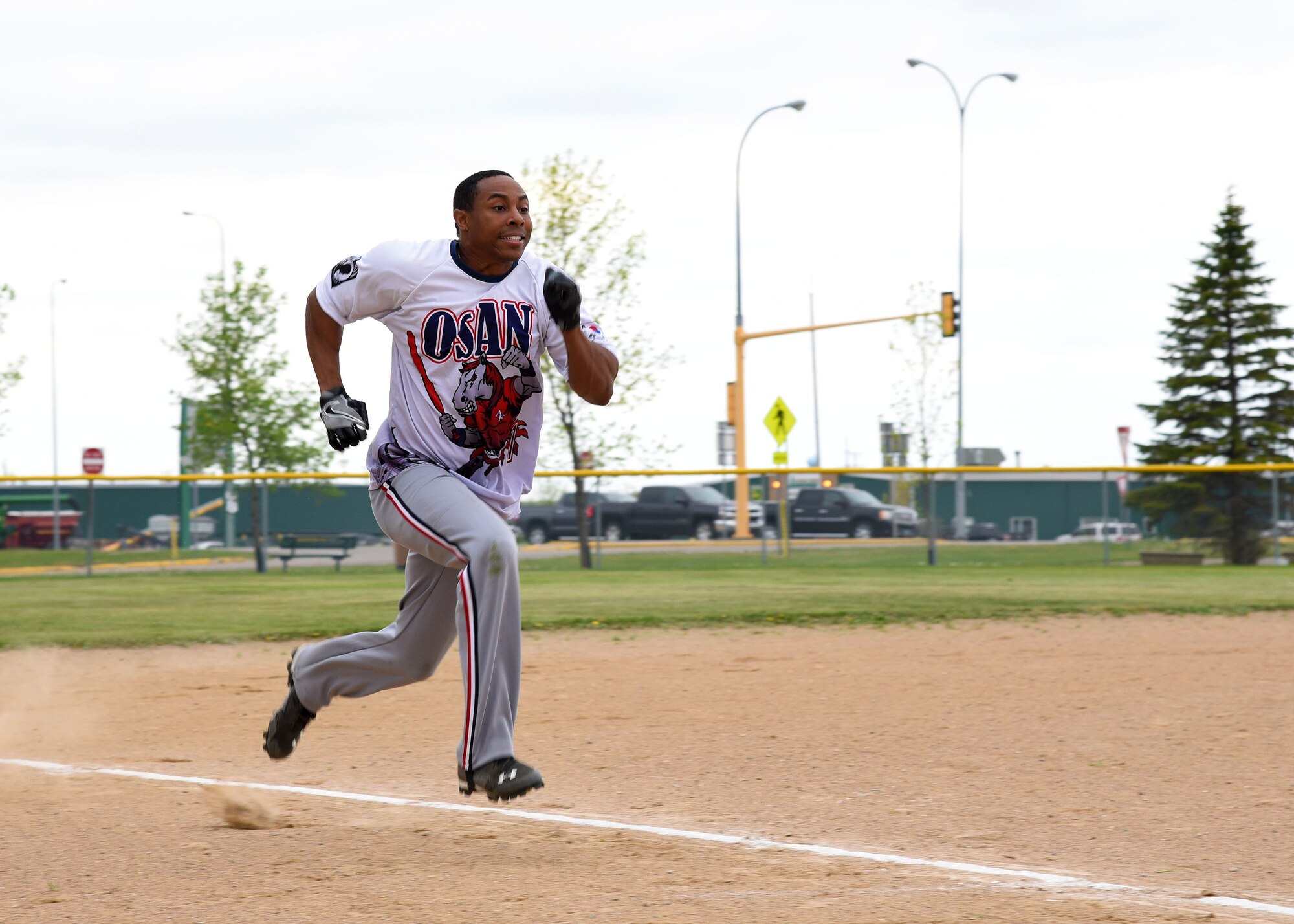 A Grand Forks AFB Airman sprints to the home plate during a play in the Grand Forks AFB versus Minot AFB annual softball tournament at Devil’s Lake, N.D., May 25, 2017. The tournament is an annual tradition between the two installations, to improve morale and allow both bases to have fun together. (U.S. Air Force photo by Airman First Class Elora McCutcheon)