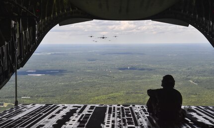 Senior Airman Cory Dye, 14th Airlift Squadron loadmaster, looks out of the cargo door of a C-17 Globemaster III during a large formation exercise, May 25, 2017. The formation contained 18 personnel loaded C-17 Globemaster IIIs and three equipment carrying C-17s from Joint Base Charleston, S.C. 
