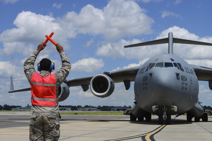 Senior Airman Ezekiel Metz, 315th Aircraft Maintenance Squadron crew chief, marshals in a C-17 Globemaster III from Joint Base Charleston, S.C., supporting a global response force exercise, May 25, 2017. Twenty one C-17s were involved in the integrated large formation exercise supporting the U.S. Army’s 82nd Airborne Division’s joint forcible entry exercise at Fort Bragg, N.C., as part of All American Week and the 82nd Abn. Div.’s 100th anniversary. (U.S. Air Force photo by Senior Airman Thomas T. Charlton)