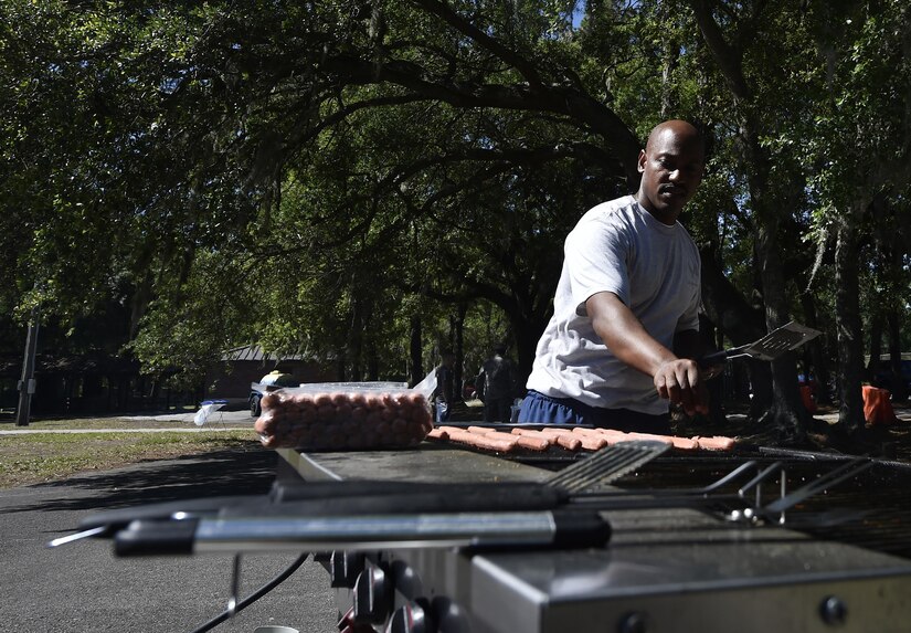 Staff Sgt. Rolando Clarke, 437th Maintenance Group, cooks hot dogs during the 437th Airlift Wing picnic at Joint Base Charleston, S.C., May 26. Attendees were able to compete in sports and play games during the event such as basketball, dodge ball, tug-of-war and ultimate Frisbee. (U.S. Air Force photo by Staff Sgt. Christopher Hubenthal)