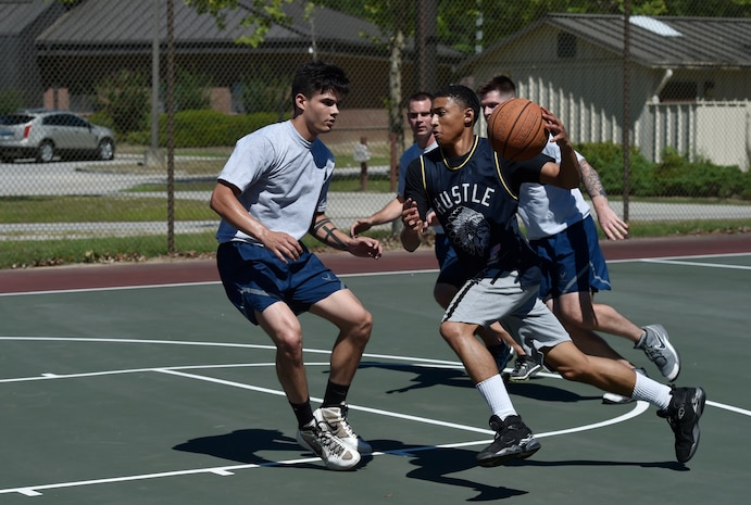 Amn Saabir Brown, 437th Maintenance Squadron, charges down the court during a basketball game as part of the 437th Airlift Wing picnic at Joint Base Charleston, S.C., May 26. Attendees were able to compete in sports and play games during the event such as basketball, dodge ball, tug-of-war and ultimate Frisbee. (U.S. Air Force photo by Staff Sgt. Christopher Hubenthal)