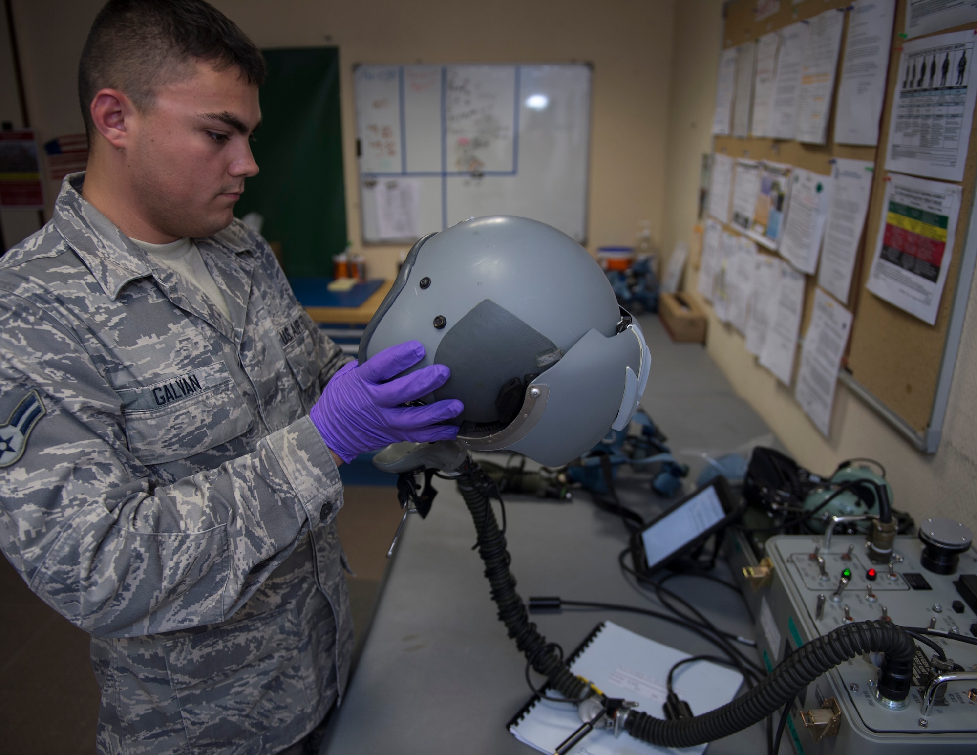 U.S. Air Force Airman 1st Class Dallas Galvan, an aircrew flight equipment technician with the 379th Expeditionary Operational Support Squadron, inspects a HGU-55/P helmet and MBU-20/P mask at Al Udeid Air Base, Qatar, May 16, 2017. Aircrew flight equipment technician’s work day and night to inspect, repair and modify helmets, combat survivor evader locators, Scott 358 Quick Don Oxygen Masks, and aircrew survival equipment kit to help keep aircrew members safe.  (U.S. Air Force photo by Tech. Sgt. Amy M. Lovgren)