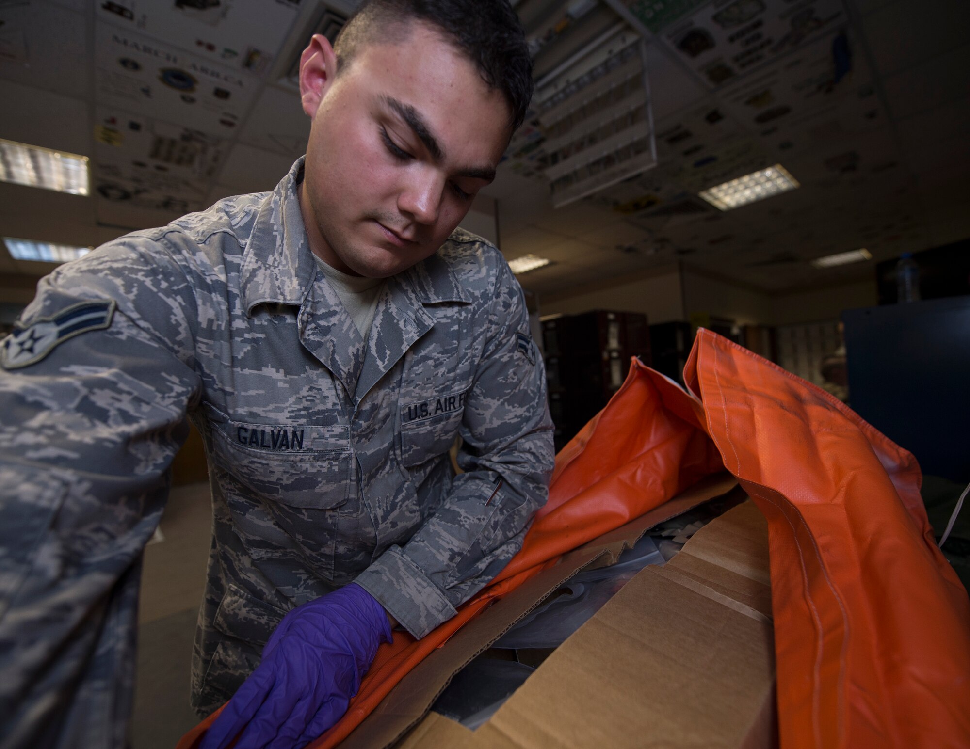 U.S. Air Force Airman 1st Class Dallas Galvan, an aircrew flight equipment technician with the 379th Expeditionary Operational Support Squadron, opens an aircrew survival equipment kit for inspection at Al Udeid Air Base, Qatar, May 16, 2017. The aircrew survival equipment kits are designed to keep aircrew members alive in the event of an emergency.  (U.S. Air Force photo by Tech. Sgt. Amy M. Lovgren)