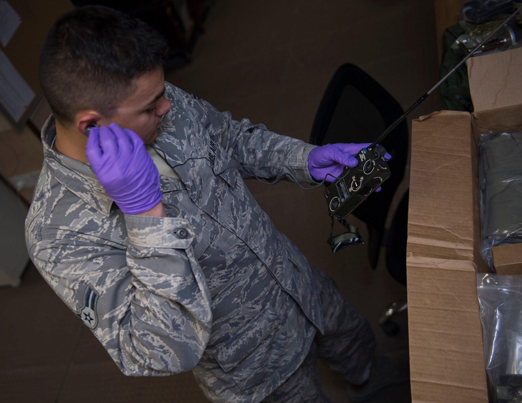 U.S. Air Force Airman 1st Class Dallas Galvan, an aircrew flight equipment technician with the 379th Expeditionary Operational Support Squadron, conducts a function check on a PRC-90 radio at Al Udeid Air Base, Qatar May 16, 2017. The PRC-90 radio is one of many items located within aircrew survival equipment kit that can help aircrew members return safely if they become isolated. (U.S. Air Force photo by Tech. Sgt. Amy M. Lovgren)