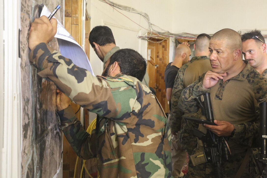 An Afghan National Army soldier with 2nd Brigade, 215th Corps and U.S. Marine advisors with Task Force Southwest plan for a clearing operation at Camp Nolay, Afghanistan, May 22, 2017. The advisors assisted their counterparts with the battle-tracking, intelligence and logistical procedures during a clearing operation in Sangin, Afghanistan. Approximately 50 Marines partook in the expeditionary advising package as part of the Task Force’s train, advise and assist mission in Helmand Province. (U.S. Marine Corps photo by Sgt. Lucas Hopkins)