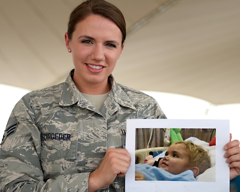 U.S. Air Force Senior Airman Juliana Schroeder, air traffic controller assigned to the 379th Expeditionary Operations Support Squadron, holds a photograph of her brother Joel at Al Udeid, Air Force Base, Qatar, May 11, 2017. In 2007, Joel was the recipient of bone marrow cells from a bone marrow donor located in Germany and since that moment, Schroeder has been a supporter of, and a vocal advocate for, bone marrow donor registration. Schroeder volunteered and worked to spread the word and encourage donors. (U.S. Air Force photo by Tech. Sgt. Bradly Schneider/Released)