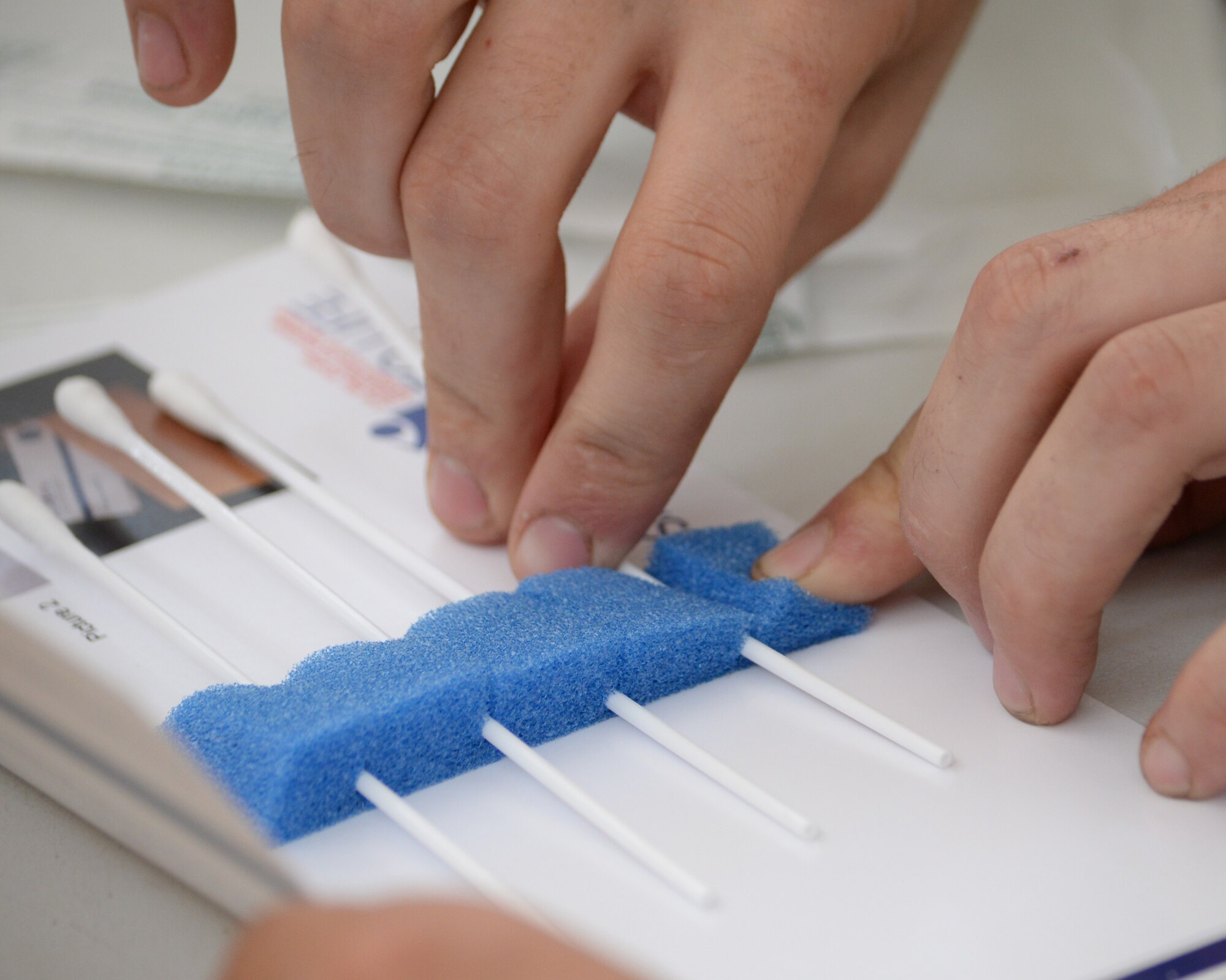 U.S. Air Force Airman 1st Class Kevin Otero, official mail clerk assigned to the 379th Expeditionary Communications Squadron, takes the cotton swab after swabbing the inside of the cheek and lips and places it back in the envelope for shipping along with the registration paperwork during the bone marrow donor registration drive held at Al Udeid, Air Force Base, Qatar, May 19, 2017. As a result of the drive, a total of 293 new donors were added to the donor list in support of a military focused bone marrow donor registry that includes U.S. military members, their families and DoD civilian employees between the ages of 18 and 60 and whose donors are then added to the National Marrow Donor Registry. (U.S. Air Force photo by Tech. Sgt. Bradly Schneider/Released)