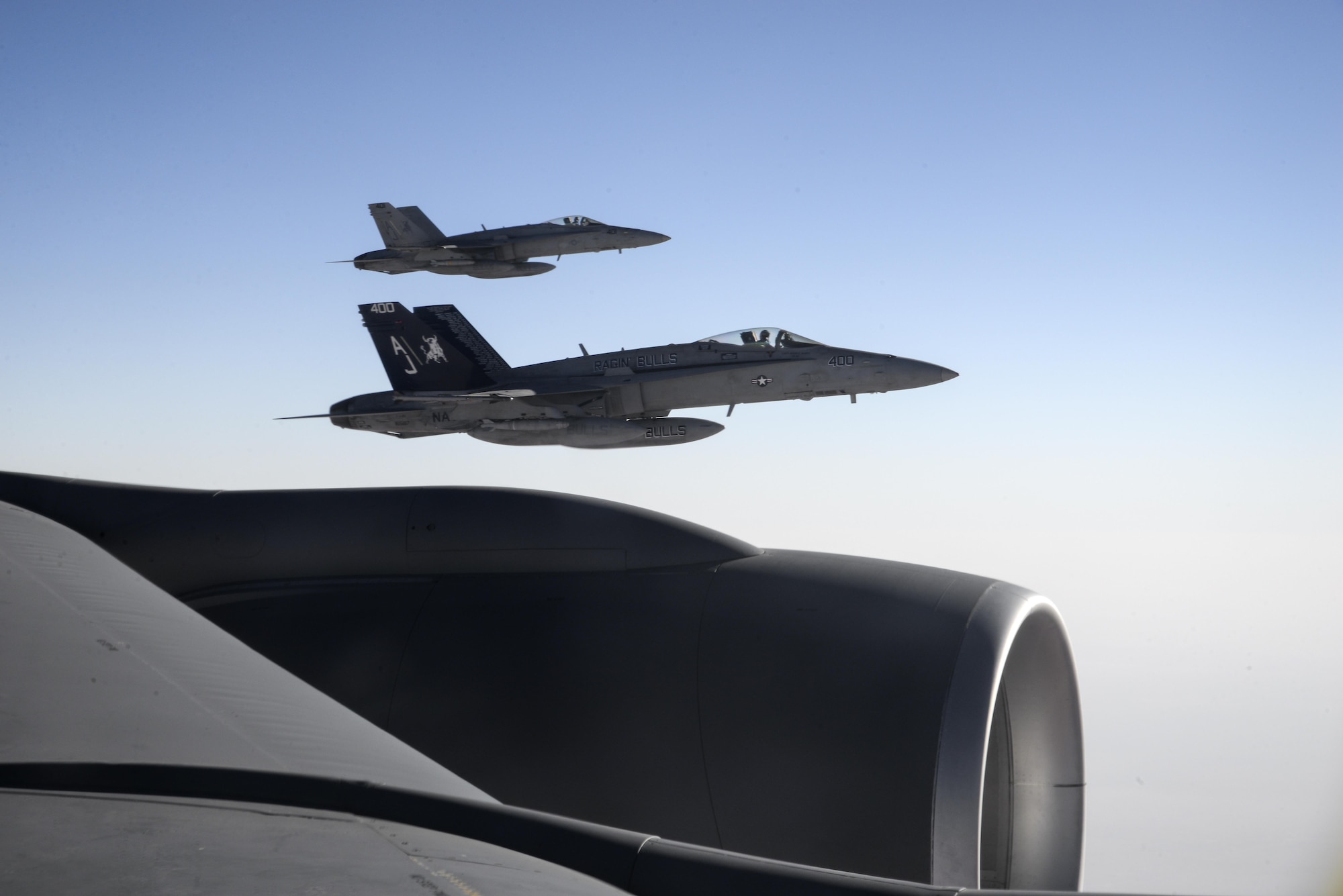 Two U.S. Navy F/A-18Cs from the Strike Fighter Squadron VFA-37 Ragin' Bulls fly in formation alongside a U.S. Air Force KC-135 Stratotanker during a combat refueling mission over Southwest Asia May 21, 2017.  KC-135 Stratotankers, from the 340th Expeditionary Air Refueling Squadron at Al Udeid Air Base, Qatar, maintain a 24/7 presence in the Area Of Responsibility, supporting U.S. and Coalition forces in the air and on the ground, contributing to Operation Inherent Resolve and the fight against ISIS. (U.S. Air National Guard photo by Master Sgt. Andrew J. Moseley/Released)