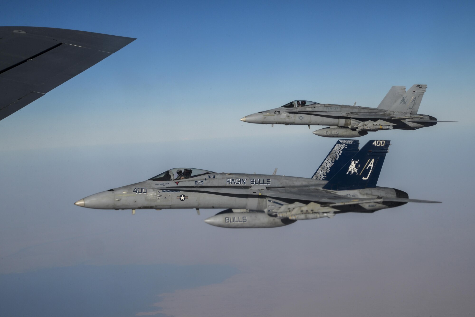 Two U.S. Navy F/A-18Cs from the Strike Fighter Squadron VFA-37 Ragin' Bulls fly in formation alongside a U.S. Air Force KC-135 Stratotanker during a combat refueling mission over Southwest Asia May 21, 2017.  KC-135 Stratotankers, from the 340th Expeditionary Air Refueling Squadron at Al Udeid Air Base, Qatar, maintain a 24/7 presence in the Area Of Responsibility, supporting U.S. and Coalition forces in the air and on the ground, contributing to Operation Inherent Resolve and the fight against ISIS. (U.S. Air National Guard photo by Master Sgt. Andrew J. Moseley/Released)