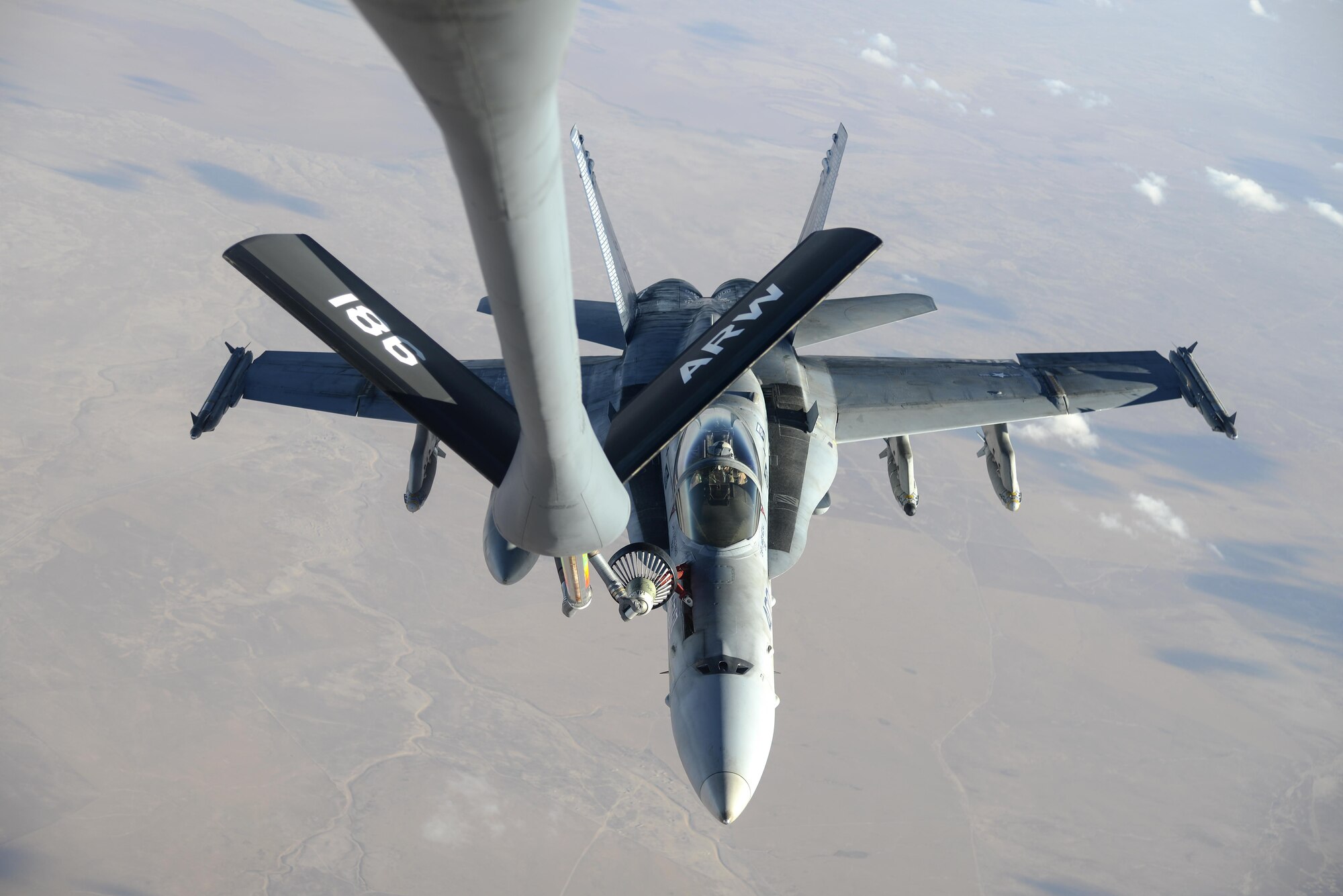 A U.S. Navy F/A-18C from the Strike Fighter Squadron VFA-37 Ragin' Bulls receives fuel in flight from a U.S. Air Force KC-135 Stratotanker over Southwest Asia May 21, 2017. Assigned to the 340th Expeditionary Air Refueling Squadron, out of Al Udeid Air Base, Qatar, the tanker from the 186th Air Refueling Wing, Mississippi Air National Guard was fitted with a drogue attached to the boom, for specialized receiver equipment on Navy and coalition aircraft. The 340th EARS maintains a 24/7 presence in the AOR, extending the missions of aircraft supporting Operation Inherent Resolve and the fight against ISIS. (U.S. Air National Guard photo by Master Sgt. Andrew J. Moseley/Released)