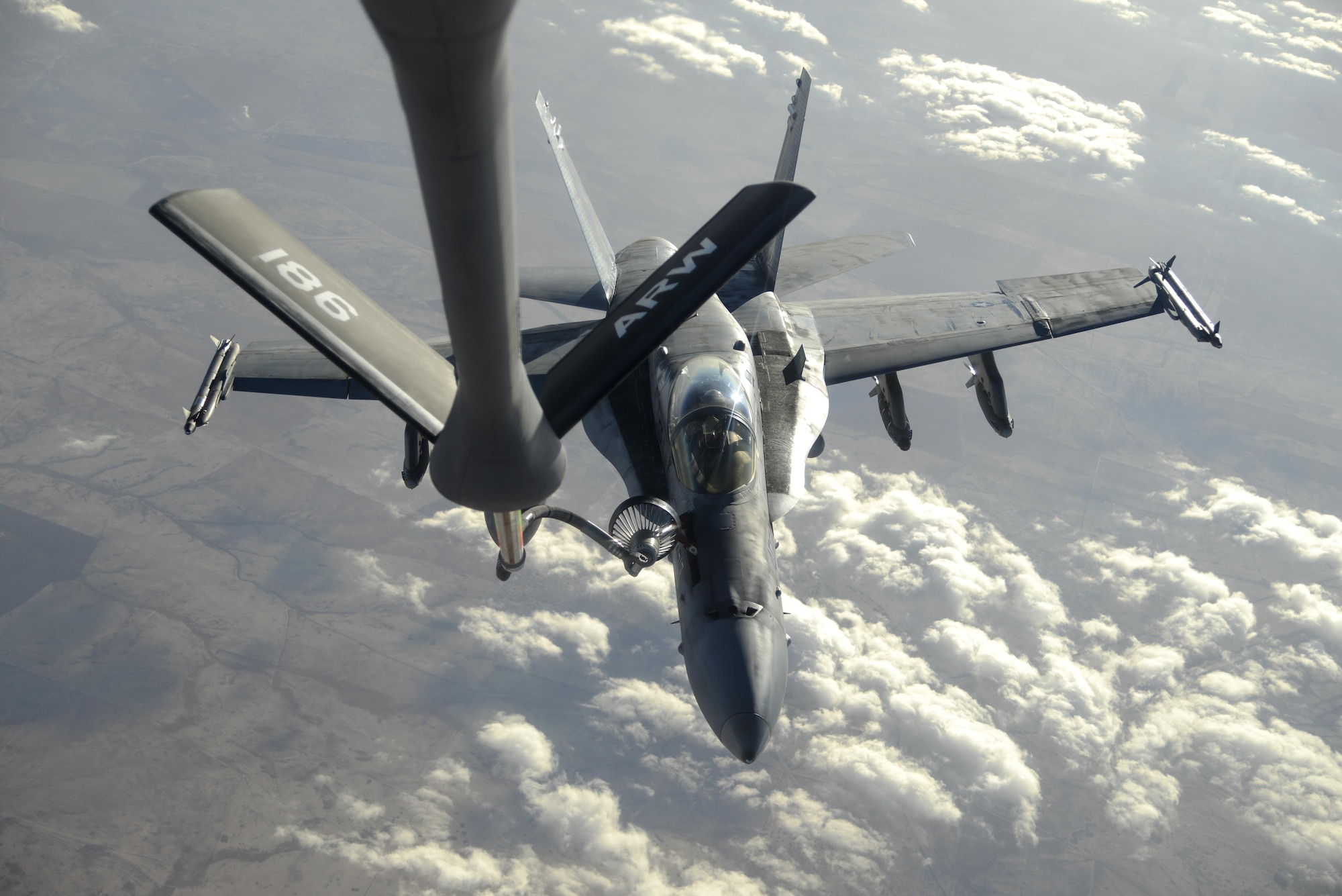 A U.S. Navy F/A-18C from the Strike Fighter Squadron VFA-37 Ragin' Bulls receives fuel in flight from a U.S. Air Force KC-135 Stratotanker over Southwest Asia May 21, 2017. Assigned to the 340th Expeditionary Air Refueling Squadron, out of Al Udeid Air Base, Qatar, the tanker from the 186th Air Refueling Wing, Mississippi Air National Guard was fitted with a drogue attached to the boom, for specialized receiver equipment on Navy and coalition aircraft. The 340th EARS maintains a 24/7 presence in the AOR, extending the missions of aircraft supporting Operation Inherent Resolve and the fight against ISIS. (U.S. Air National Guard photo by Master Sgt. Andrew J. Moseley/Released)