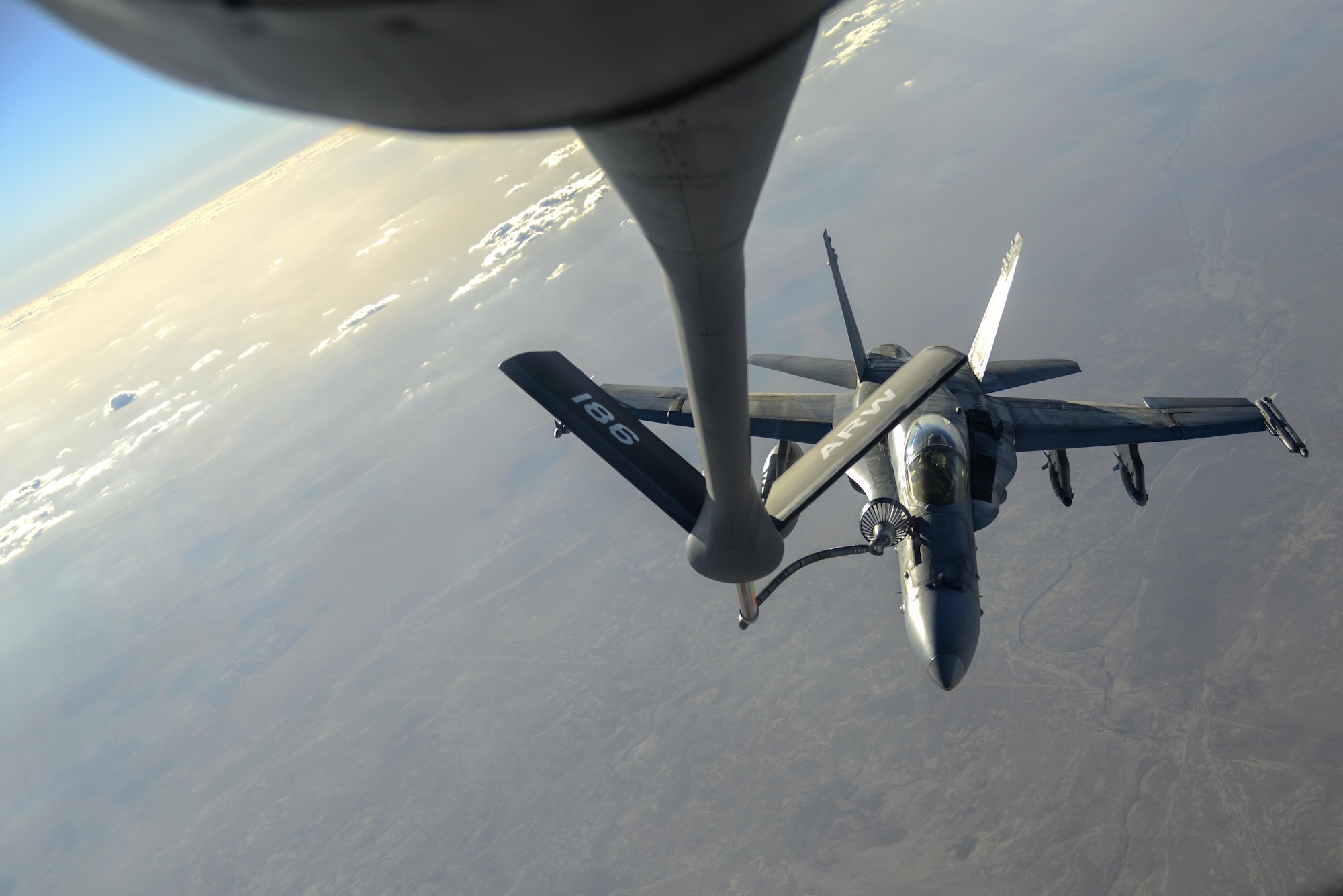 A U.S. Navy F/A-18C from the Strike Fighter Squadron VFA-37 Ragin' Bulls receives fuel in flight from a U.S. Air Force KC-135 Stratotanker over Southwest Asia May 21, 2017. Assigned to the 340th Expeditionary Air Refueling Squadron, out of Al Udeid Air Base, Qatar, the tanker from the 186th Air Refueling Wing, Mississippi Air National Guard was fitted with a drogue attached to the boom, for specialized receiver equipment on Navy and coalition aircraft. The 340th EARS maintains a 24/7 presence in the AOR, extending the missions of aircraft supporting Operation Inherent Resolve and the fight against ISIS. (U.S. Air National Guard photo by Master Sgt. Andrew J. Moseley/Released)