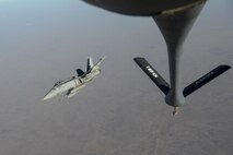 A U.S. Navy F/A-18C from the VFA-37 Ragin' Bulls breaks right after receiving fuel from a U.S. Air Force KC-135 Stratotanker over Southwest Asia May 21, 2017.  Assigned to the 340th Expeditionary Air Refueling Squadron, out of Al Udeid Air Base, Qatar, the tanker from the 186th Air Refueling Wing, Mississippi Air National Guard was fitted with a drogue attached to the boom, for specialized receiver equipment on Navy and coalition aircraft. The 340th EARS maintains a 24/7 presence in the AOR, extending the missions of aircraft supporting Operation Inherent Resolve and the fight against ISIS. (U.S. Air National Guard photo by Master Sgt. Andrew J. Moseley/Released)