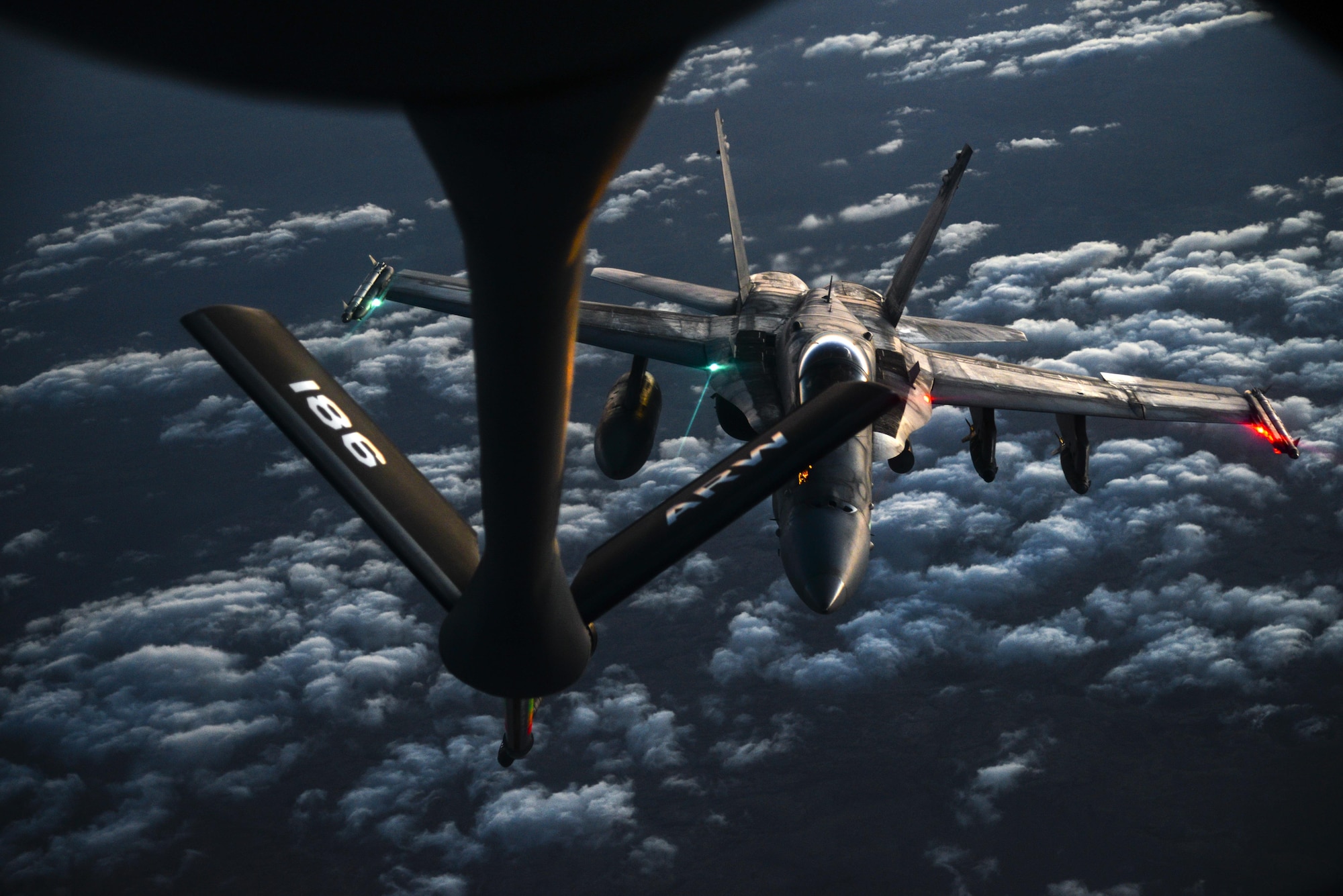 A U.S. Navy F/A-18C from the VFA-37 Ragin' Bulls prepares to receive fuel from a U.S. Air Force KC-135 Stratotanker over Southwest Asia May 21, 2017. Assigned to the 340th Expeditionary Air Refueling Squadron, Al Udeid Air Base, Qatar, the tanker from the 186th Air Refueling Wing, Mississippi Air National Guard is fitted with a drogue attached to the boom, for specialized receiver equipment on Navy and coalition aircraft. The 340 EARS tankers maintain a 24/7 presence in the Area Of Responsibility, supporting U.S. and coalition aircraft participating in Operation Inherent Resolve and the fight against ISIS. (U.S. Air National Guard photo by Master Sgt. Andrew J. Moseley/Released)