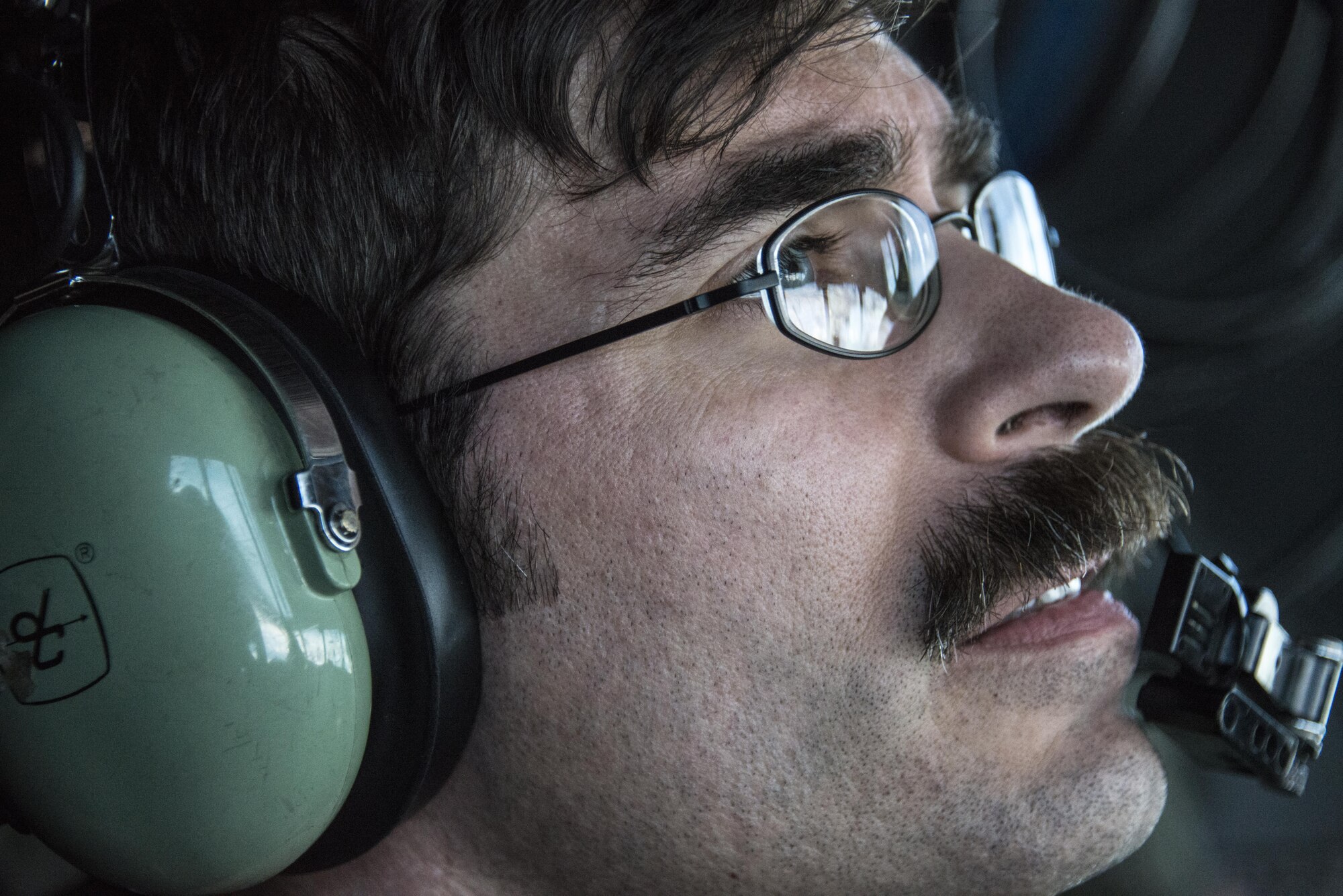 A U.S. Air Force 1st Special Operations Squadron flight engineer looks out the window of a U.S. Air Force MC-130H Combat Talon II during a aerial refueling from a KC-135 Stratotanker assigned to the 452nd Air Mobility Wing, April 14, 2017 over the Pacific. The 353rd Special Operations Group traveled from Kadena Air Base, Japan to Royal New Zealand Air Force Base Auckland, New Zealand, to support Exercise Teak Net. (U.S. Air Force photo by Capt. Jessica Tait)