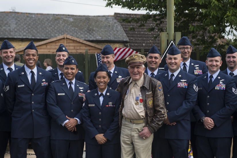 Douglas Ward, 305th Bombardment Group veteran, takes a photo with current members of the 305th Air Mobility Wing, now stationed at Joint Base McGuire-Dix-Lakehurst, New Jersey, in front of the 305th BG memorial in Chelveston, England on May 27. Ward Served in the 305th BG from 1942-1945. (U.S. Air Force photo by Senior Airman Joshua King)