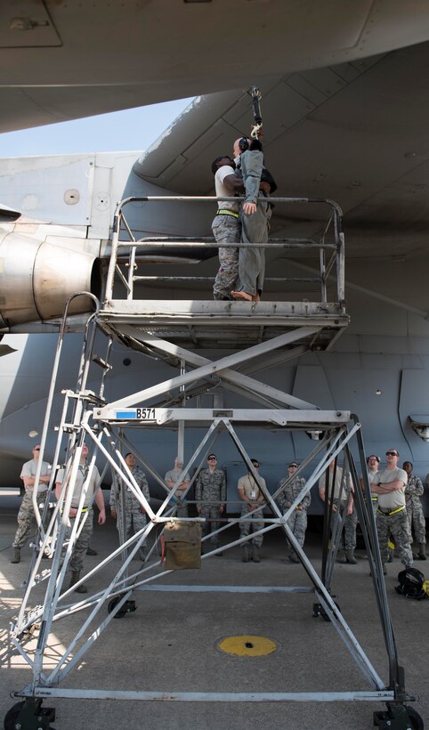 U.S. Air Force Staff Sgt. Henry Thomas III, crew chief assigned to the 728th Air Mobility Squadron, demonstrates how to unhook a training dummy from the wing of a C-17 Globemaster III during fall and rescue training May 25, 2017, at Incirlik Air Base, Turkey. SSgt Thomas also demonstrate the step-by-step process in the fall and rescue procedures. (U.S. Air Force photo by Senior Airman Jasmonet D. Jackson)