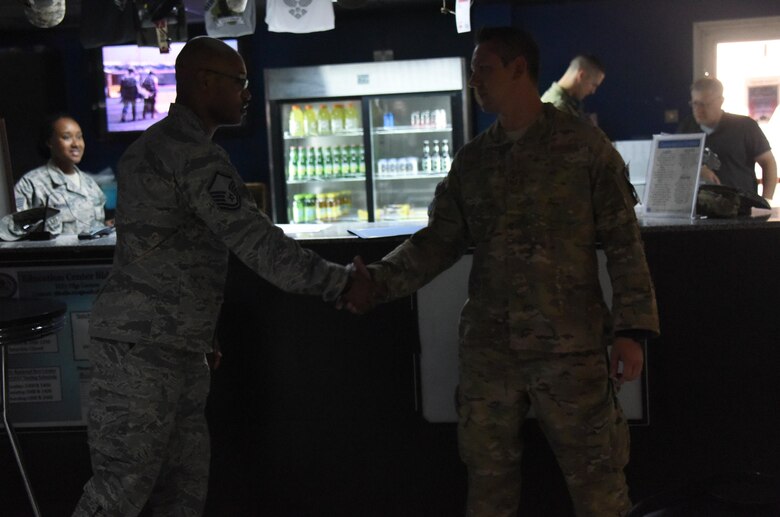 Master Sgt. Jermaine Hall shakes the hand of Tech. Sgt. Peter H. Demkow Jr. as he congratulates Demkow on his selection for master sergeant at an undisclosed location in Southwest Asia, May 24, 2017. The 386th Air Expeditionary Wing Top Three organization hosted a master sergeant release party to celebrate the five technical sergeants that were selected for master sergeant.  (U.S. Air Force photo/Tech. Sgt. Jonathan Hehnly)